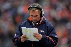 Mike Shanahan looks at his playbook (Getty Images)