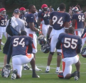 Andra Davis (54), Jarvis Moss (94) and D.J. Williams (55) watch teammates participate in drills during Denver Broncos training camp on Wed. Aug. 5, 2009.  (BroncoTalk/Kyle Montgomery)