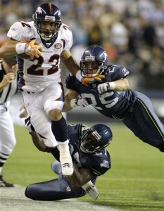 Seattle Seahawks' Jordan Babineaux, bottom, and Brian Russell, right, tackle Denver Broncos' Peton Hillis (22) in the first half of an NFL preseason football game, Saturday, Aug. 22, 2009, in Seattle. (AP Photo/Ted S. Warren)