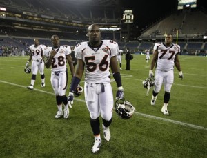 Denver Broncos' Robert Ayers (56) walks off the field with teammates Correll Buckhalter (28) and Brandon Gorin, right, after the Seattle Seahawks beat the Broncos 27-13 in a NFL preseason football game, Saturday, Aug. 22, 2009, in Seattle. (AP Photo/Ted S. Warren)