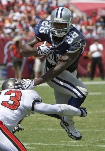 Dallas Cowboys running back Felix Jones (R) eludes Tampa Bay Buccaneers safety Jermaine Phillips during the 1st half of their NFL football game at Raymond James Stadium in Tampa, Florida September 13, 2009.      REUTERS/Pierre DuCharme (UNITED STATES SPORT FOOTBALL)