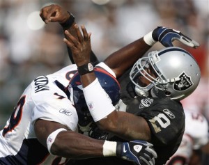 Oakland Raiders quarterback JaMarcus Russell (2) is tackled by Denver Bronco's Vonnie Holliday in the fourth quarter of a NFL football game Sunday, Sept. 27, 2009, in Oakland, Calif. (AP Photo/Ben Margot)
