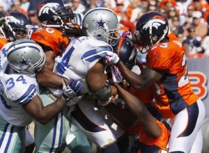 Dallas Cowboys running back Marion Barber (C) powers his way into the endzone to score a first quarter touchdown against the Denver Broncos in their NFL football game in Denver October 4, 2009. (REUTERS/Rick Wilking)