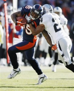 Denver Broncos wide receiver Brandon Marshall (15) is tackled by Oakland Raiders safety Michael Huff after Marshall pulled in a pass in the first quarter of an NFL  football game in Denver on Sunday, Dec. 20, 2009. (AP Photo/Jack Dempsey)