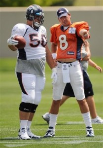 Denver Broncos quarterback Kyle Orton (8) talks with rookie lineman J.D. Walton (50) from Baylor during NFL football training camp at Broncos headquarters in Englewood, Colo., Monday, Aug. 2, 2010. (AP Photo/Jack Dempsey)