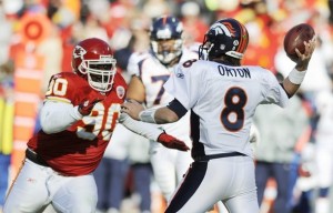 Denver Broncos quarterback Kyle Orton (8) passes just before Kansas City Chiefs defensive tackle Shaun Smith (L) reaches him in the first half of their NFL football game in Kansas City, Missouri December 5, 2010. (REUTERS/Dave Kaup)