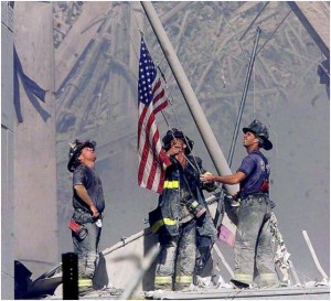 Firefighters raise the American flag following the tragedy of 9/11