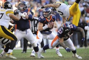 Denver Broncos running back Willis McGahee (23) throws a block on Pittsburgh Steelers inside linebacker Larry Foote (50) as Denver Broncos quarterback Tim Tebow (15) looks to pass in the second quarter of an NFL wild card playoff football game Sunday, Jan. 8, 2012, in Denver.  (AP Photo/Jack Dempsey)