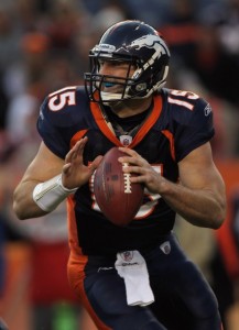 Quarterback Tim Tebow #15 of the Denver Broncos rolls out and looks to deliver a pass against the Houston Texas at INVESCO Field at Mile High on December 26, 2010 in Denver, Colorado. The Broncos defeated the Texans 24-23.  (Photo by Doug Pensinger/Getty Images)