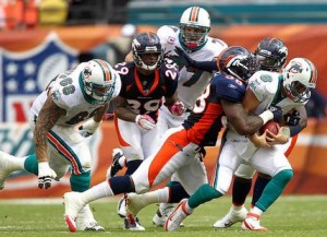 Von Miller takes down Dolphins quarterback Matt Moore (right) during the Broncos' overtime win on Sunday, Oct. 23, 2011.