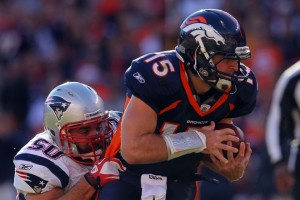 Quarterback Tim Tebow #15 of the Denver Broncos breaks a tackle against outside linebacker Rob Ninkovich #50 of the New England Patriots at Sports Authority Field at Mile High on December 18, 2011 in Denver, Colorado.  (Photo by Doug Pensinger/Getty Images)