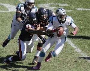 Carolina Panthers quarterback Cam Newton (1) is chased by Chicago Bears defensive end Julius Peppers (90) and linebacker Brian Urlacher (54) in the second half of an NFL football game in Chicago, Sunday, Oct. 2, 2011. (AP Photo/Kiichiro Sato)