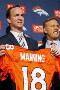 New Denver Broncos quarterback Peyton Manning holds a Broncos jersey next to vice president of football operations John Elway during an NFL football news conference at the Broncos headquarters in Englewood, Colo.,  on Tuesday, March 20, 2012. (AP Photo/David Zalubowski)