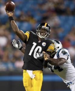 Pittsburgh Steelers quarterback Dennis Dixon (10) throws a pass while being chased by Carolina Panthers linebacker Jason Williams (R) during a NFL football game in Charlotte, North Carolina September 1, 2011. REUTERS/Chris Keane